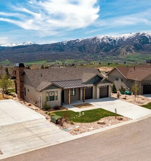 A residential area with houses featuring a ranch-style design, a driveway, and a well-maintained lawn.