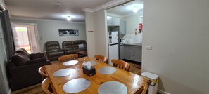 Un espace de vie compact comprenant un coin repas, une cuisine et un coin salon.