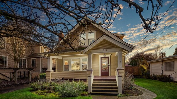 A two-story house with a front porch, a visible number '520' on the front, and a well-maintained lawn.