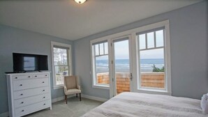 Une chambre à coucher avec un lit, une commode, une chaise et un téléviseur.