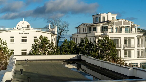 A modern building with a dome and a large balcony, surrounded by trees. - Ferienwohnung 7 "auszeit" in der Villa Annabelle (Binz)
