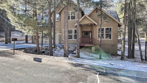 A two-story house with a front porch, surrounded by tall pine trees. - Flagstaff Family Getaway ~ 4 Miles to Downtown! (Flagstaff)