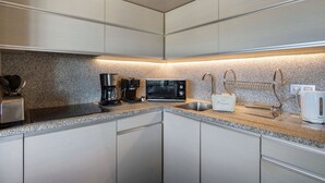 A modern kitchen with stainless steel appliances, a granite countertop, and a built-in oven. - Renovated top-floor apartment with slope access, sleeps 6 (Courchevel 1650)