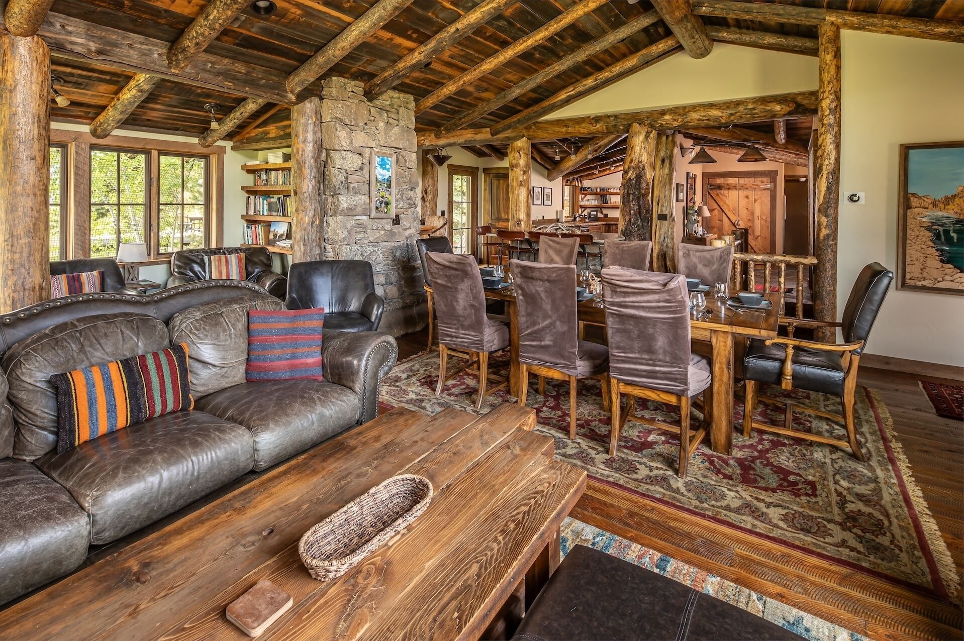 Gather around rustic wood beams and natural stone in your spacious great room, where leather seating and a welcoming dining area create the perfect mountain lodge retreat.