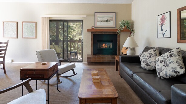 A living room with a fireplace, a sofa, a coffee table, and a chair. - Great Location. Walk to Main Street. Fireplace. (Frisco)