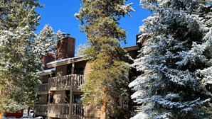 A multi-story building with a wooden balcony and snow-covered trees. - Great Location. Walk to Main Street. Fireplace. (Frisco)