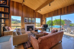 A spacious living room with a fireplace, a television, and a hot tub.
