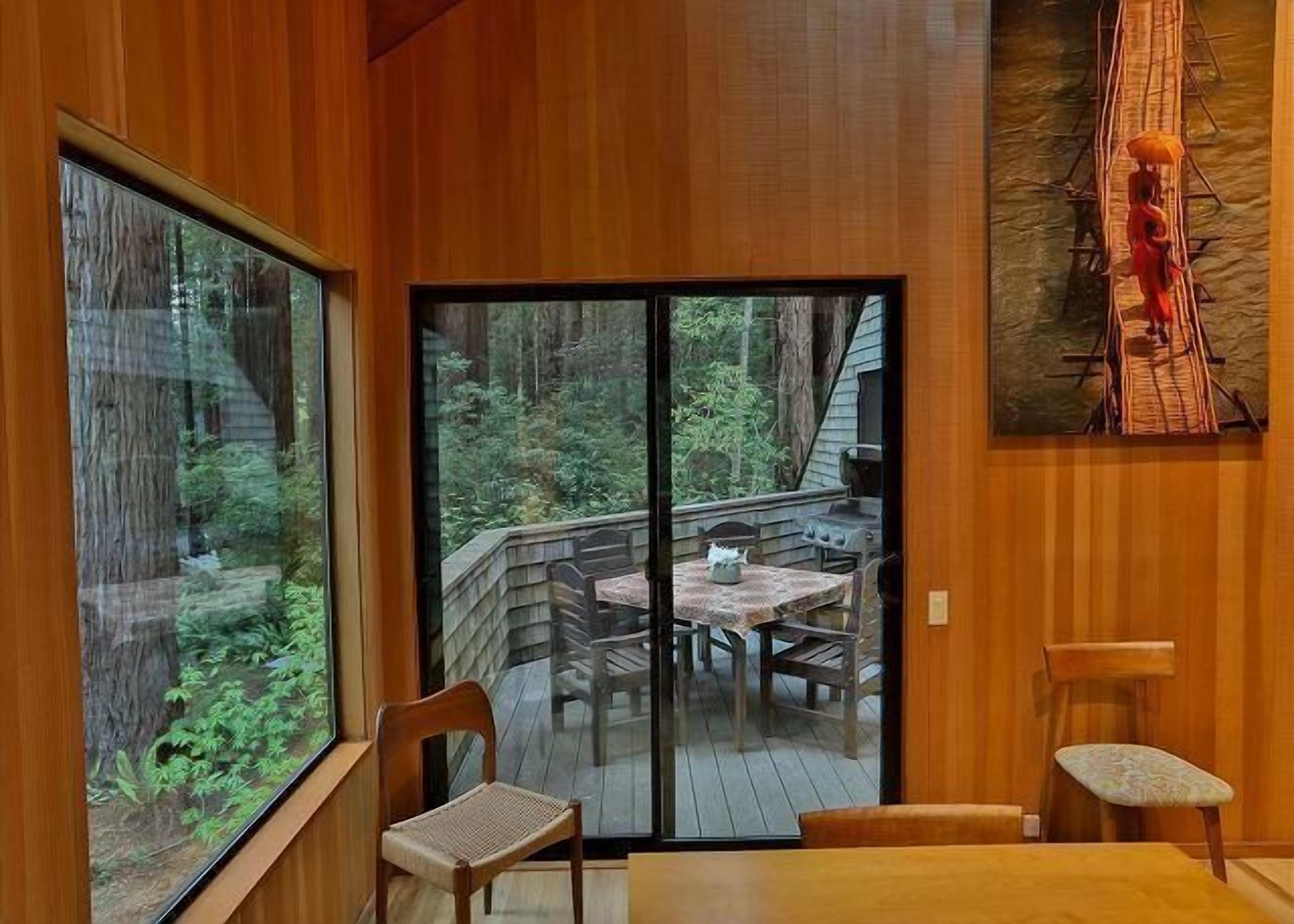 Interior de madera con puerta corredera de vidrio que da a una terraza exterior.