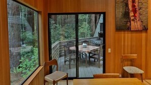 Een houten interieur met een schuifglazen deur die uitkomt op een terras.