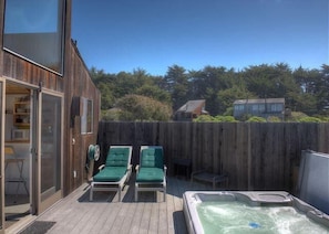 Eine Holzterrasse mit Liegestühlen und einem Whirlpool.