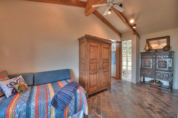 A bedroom with a bed, a wardrobe, and a dresser.
