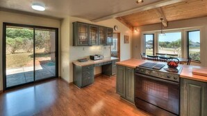 A kitchen with a large island, built-in cabinets, and a view of the outdoors.