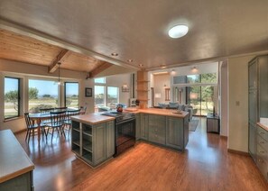 A spacious kitchen with a large island, wooden flooring, and ample natural light. - Sandpiper Nest | Coastal Escape Near Walk On Beach (The Sea Ranch)