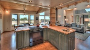 A spacious kitchen with a large island, built-in cabinets, and a view of the outdoors.