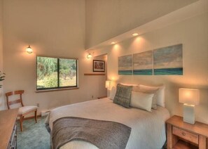 A bedroom with a bed, bedside lamps, a window, and artwork on the wall. - Sandpiper Nest | Coastal Escape Near Walk On Beach (The Sea Ranch)