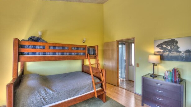 A room with a bunk bed, a desk with a lamp, and a painting on the wall. - Silver Mist | Pool with Stargazing Decks (The Sea Ranch)