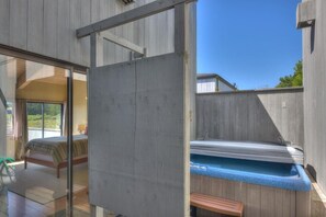 A room with a bed, a window, and a sauna area.
