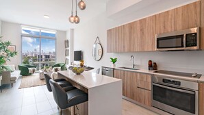 Una cocina moderna con una isla central, electrodomésticos de acero inoxidable y vistas a la ciudad.