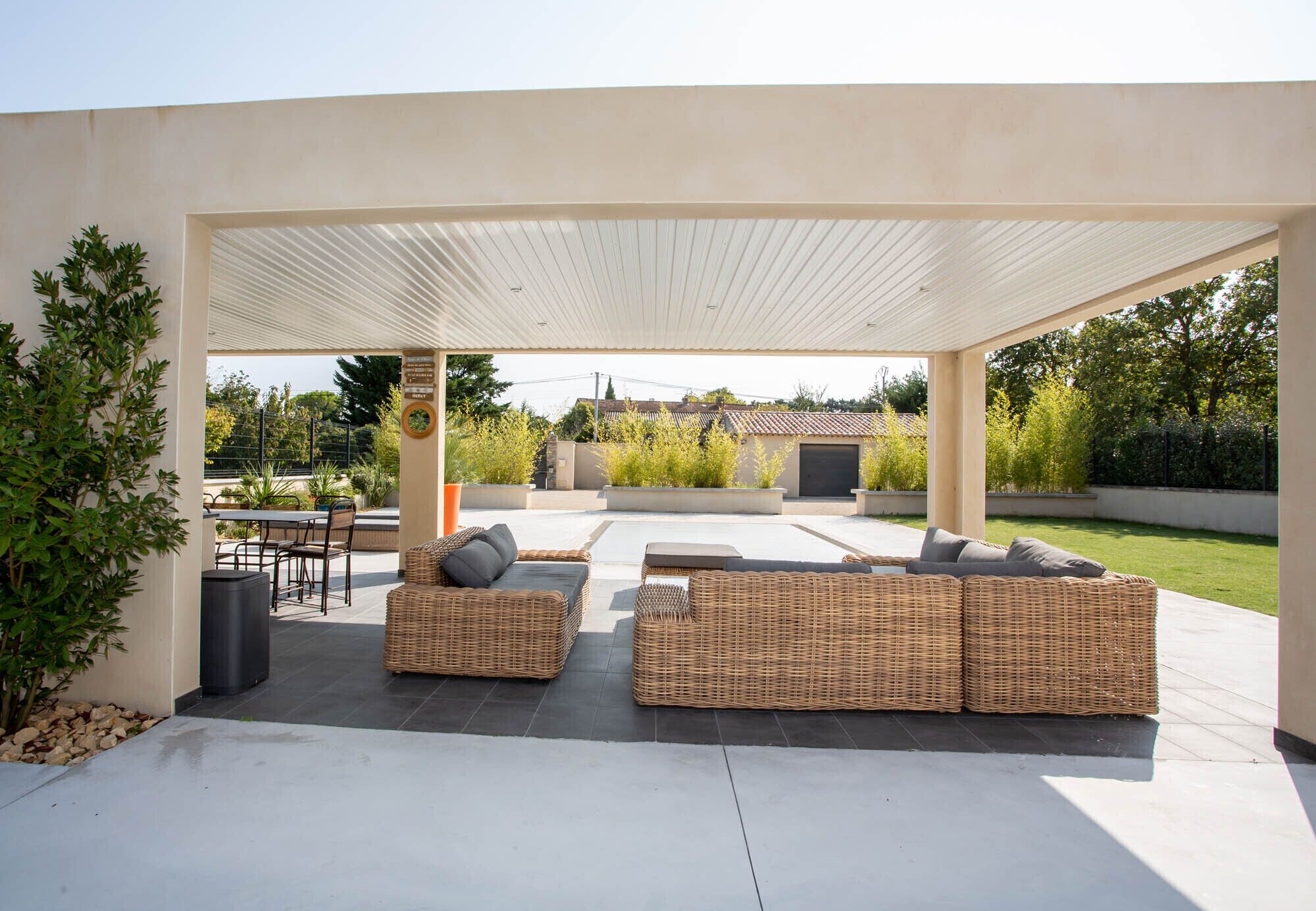 An outdoor patio with wicker furniture and a covered area.