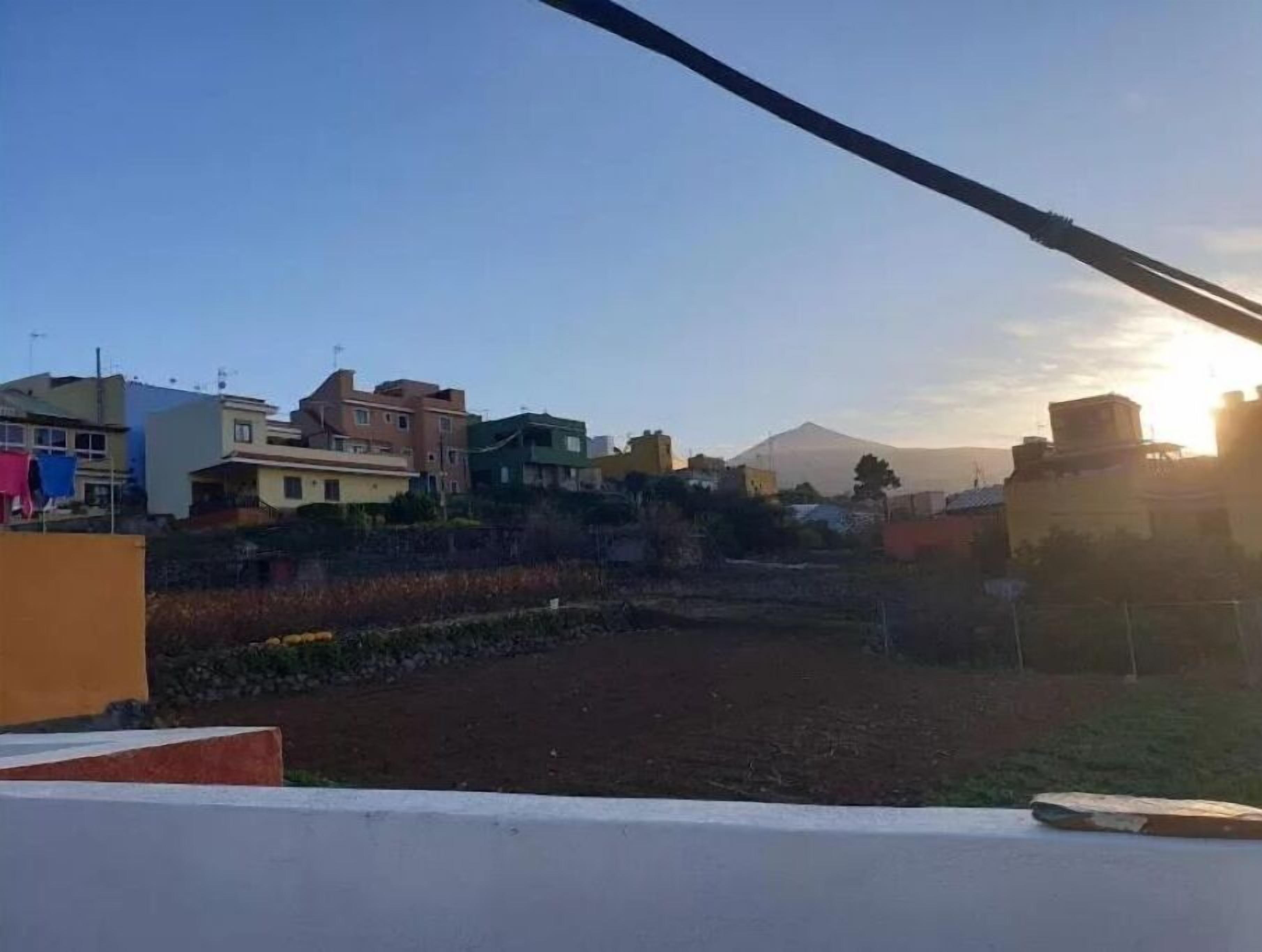 Zona residencial con casas, una montaña al fondo y cielo despejado.