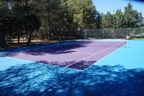 An outdoor tennis court surrounded by trees. - Le Domaine d'Alèzen (Grans)