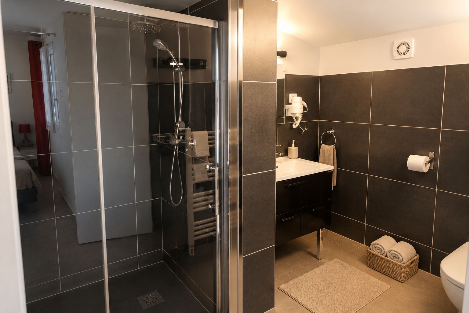 A modern bathroom with a glass-enclosed shower, a white sink, and a toilet.