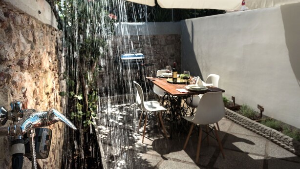 Un patio con mesa, sillas y una fuente de agua.