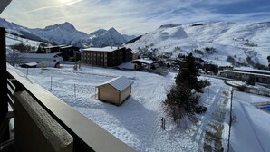 Un paysage de montagne enneigé, avec des bâtiments et un ciel dégagé.