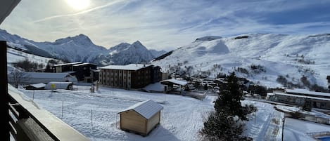 A snowy mountain landscape with buildings and a clear sky.