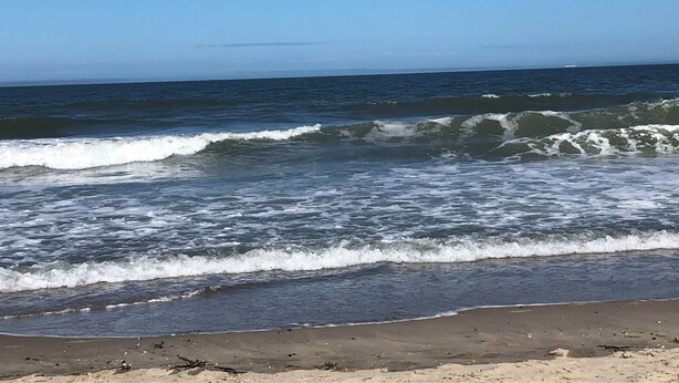 A beach with waves crashing onto the shore under a clear sky. - Beautiful spacious family friendly home in Rehoboth Beach with Pool (Rehoboth Beach)
