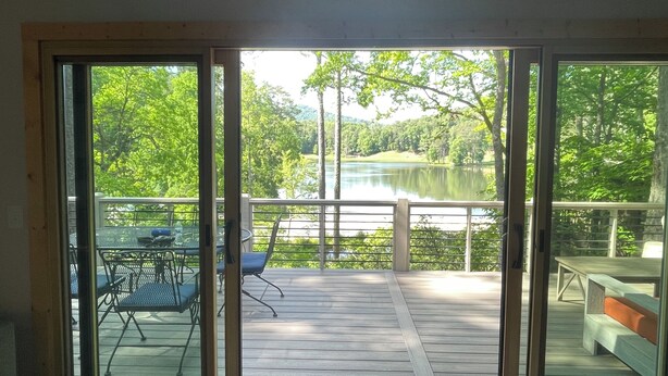 A deck with a view of a lake and trees. - Breathtaking lake views, steps from beach, golf, and clubhouse. Renovated home! (Big Canoe)
