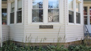 A corner building with a sign reading "NIRVANA" and a small porch area. - Spacious Updated Victorian, A/C, Walk to Beach, Close to Town  (Narragansett)