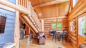 A log cabin interior with a wooden staircase, a dining area, and a fireplace. - Fontana View 1 - Ridgetop - Gated Community (Almond)