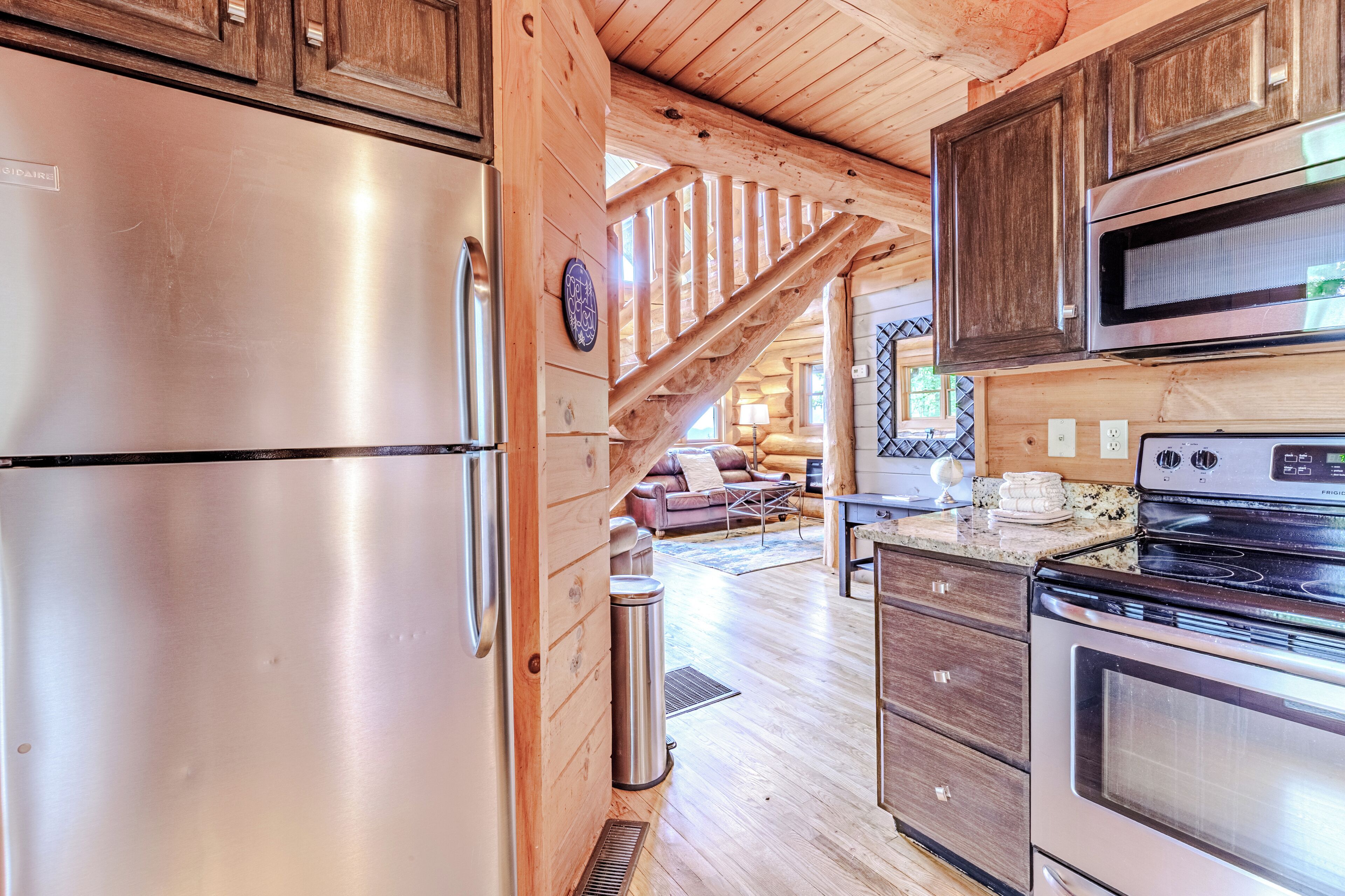 Une cuisine dotée de meubles en bois, d’appareils électroménagers en acier inoxydable et d’un plan de travail en pierre.