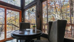 Una habitación con un ventanal grande, una mesa redonda y dos sillas.