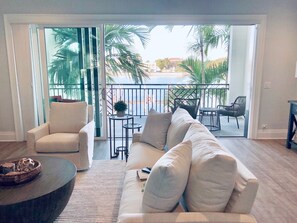 Relax on the plush sofa and take in the serene views of the water and palm trees from the balcony.