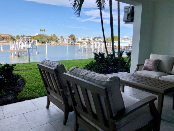 Relax in a serene outdoor seating area overlooking the marina, surrounded by lush greenery and comfortable seating.