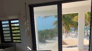 A kitchen with a granite countertop and a view of a beach through a glass door. - SanCrisanto House (San Crisanto)
