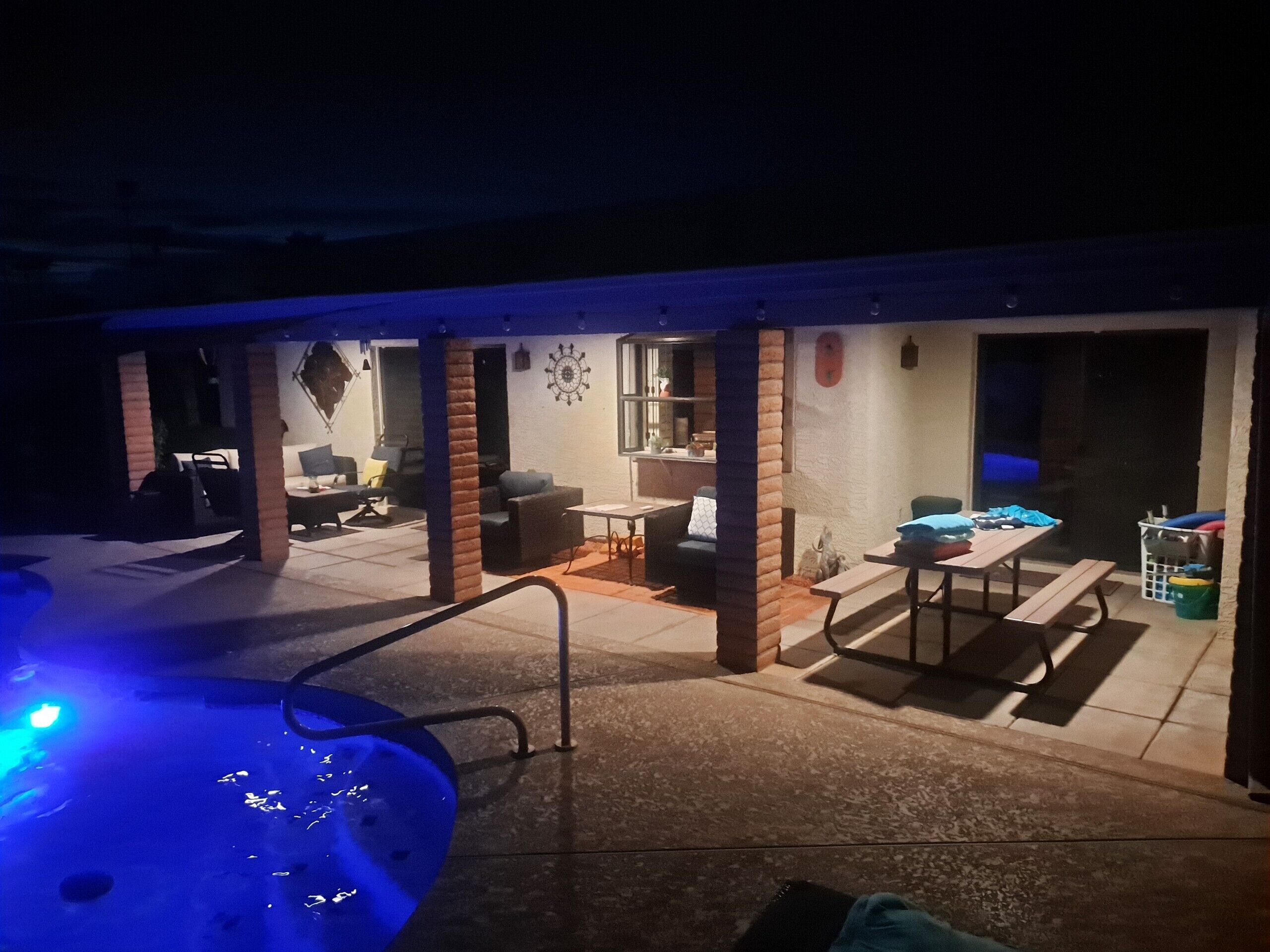 Ein Außenbereich mit Terrasse, Whirlpool, Sitzgelegenheiten und einem Tisch.