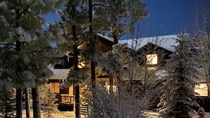 Un paisaje nevado con una casa y árboles.