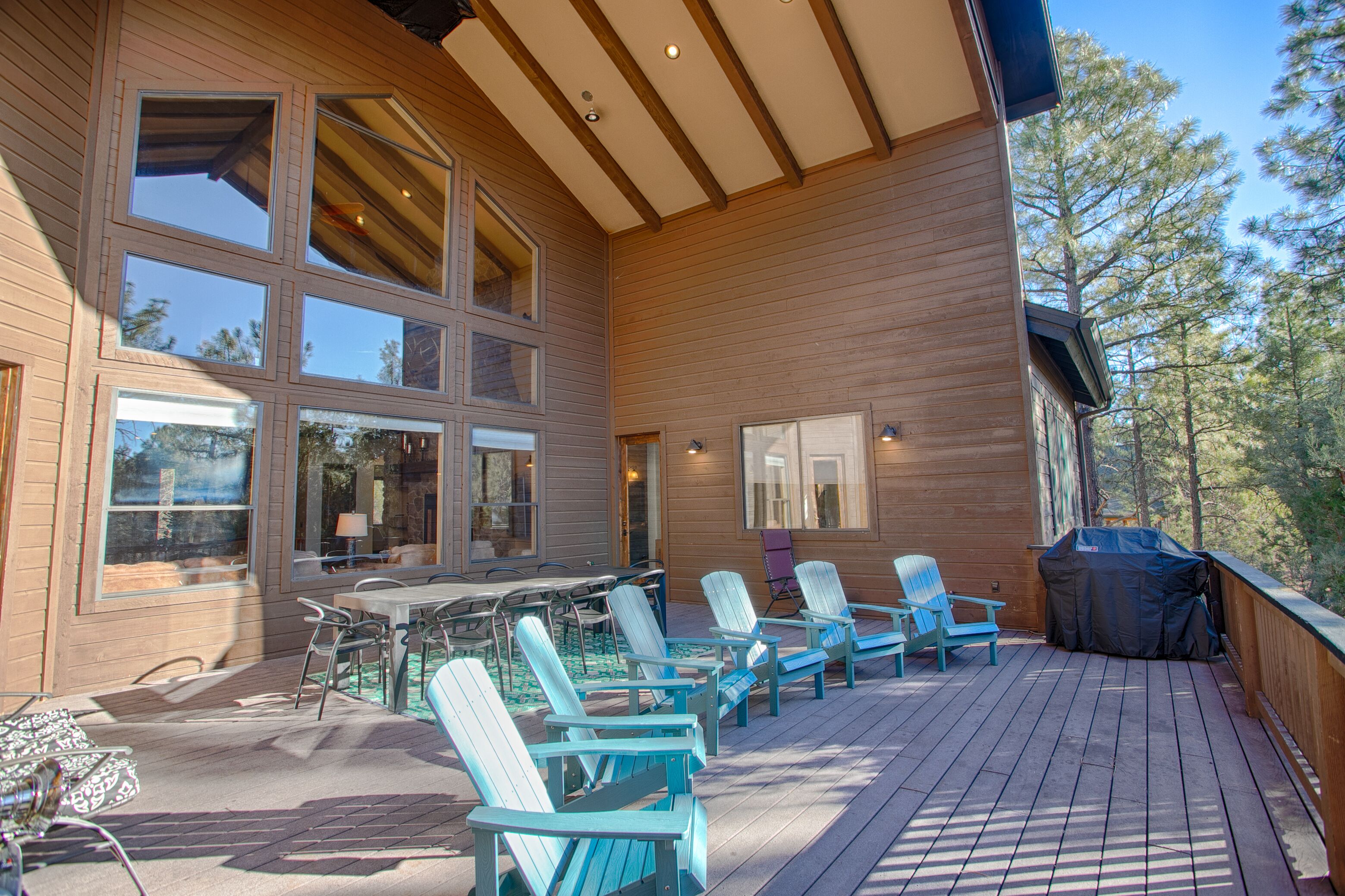 A wooden deck with outdoor furniture and a barbecue grill.