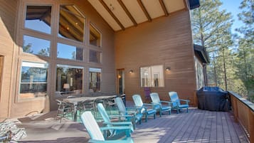 A wooden deck with outdoor furniture and a barbecue grill.