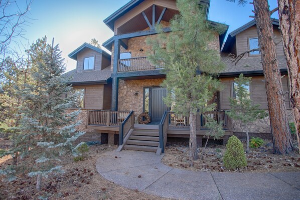 A multi-story house with a stone facade, wooden balconies, and a front porch with steps. - Beautiful Torreon Cabin Retreat in the Pines -20+ (Show Low)
