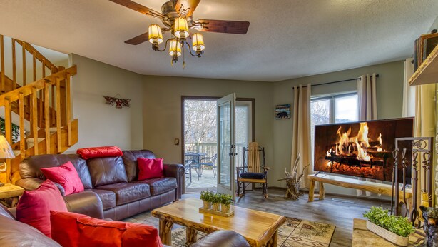 A cozy living room with a fireplace, leather sofa, and a television.