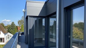 En moderne bygning med store glasvinduer og en metalfacade.