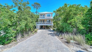 A two-story house with a covered porch and a stone pathway leading to the entrance. - The Seahorse 30A! Golf Cart Included! Sleeps 10! (Santa Rosa Beach)