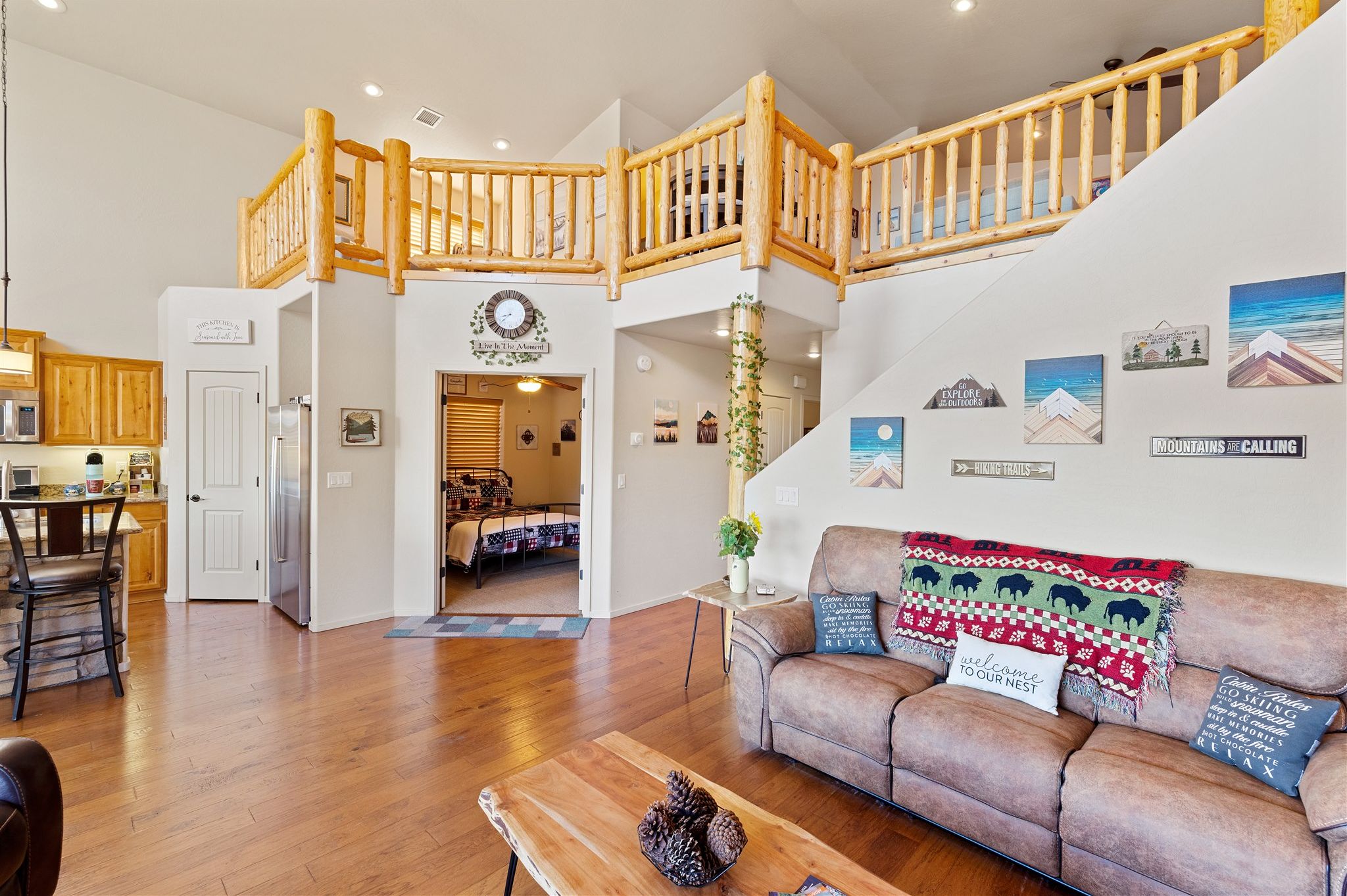 A spacious living area with a wooden staircase, a sofa with decorative pillows, and a coffee table.