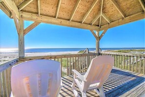 A wooden deck with two white chairs overlooking a beach. - Wide Ocean Front, Private Gazebo, 6 Bedrooms, New to VRBO (Ocean Isle Beach)