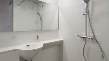 A modern bathroom with a white sink, mirror, and shower.