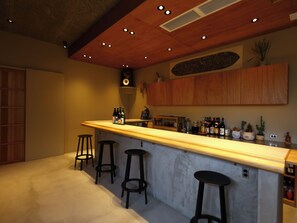 A bar area with stools, a counter, and various bottles. - Mustard Hotel Shimokitazawa (Tokyo)